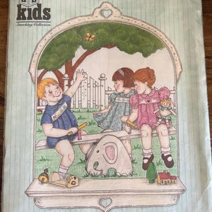 May include: A clear plastic bag containing a sewing pattern for children's clothing. The pattern features an illustration of three children on a seesaw, with the text "ab kids Smocking Collection" and "Justin-Julie-Stephanie". The pattern is sized for 6, 12, 18, and 24 months.