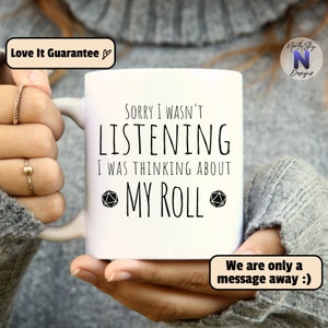 May include: White ceramic mug with a black design that says "Sorry I wasn't listening, I was thinking about my roll." with a dice symbol on either side of the text.