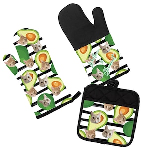 May include: A set of two black and white oven mitts and a pot holder with a pattern of avocados and cats. The text "Wallace in Grommet" is printed on the oven mitt.