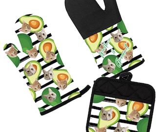 Puede incluir: Un juego de dos guantes de horno negros y blancos y un posavasos con un patrón de aguacates y gatos. El texto "Wallace in Grommet" está impreso en el guante de horno.