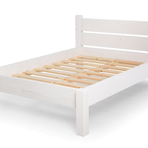 Op de afbeelding: Wit houten bedframe met lattenbodem. Het bedframe heeft een eenvoudig ontwerp met een rechthoekig hoofdbord en voetbord.