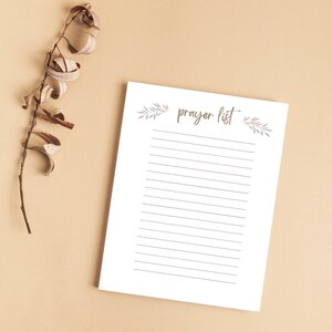 May include: A white printable prayer list with the words "prayer list" written in brown cursive. The list is decorated with small grey floral designs at the top and bottom.