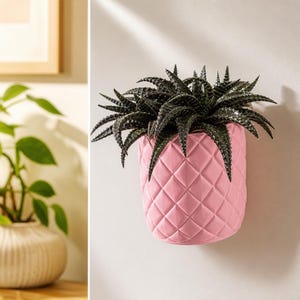 Puede incluir: Una maceta de pared con forma de piña, acabado en rosa claro y textura de patrón de diamantes. La maceta contiene una planta suculenta de color verde oscuro con hojas puntiagudas y espinosas que se abren desde el centro del recipiente.