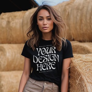 May include: A woman wearing a black t-shirt with the text "YOUR DESIGN HERE" in white. The shirt is a mock-up for a design and has the text "NATIVE MOCKS" above and below the design area.