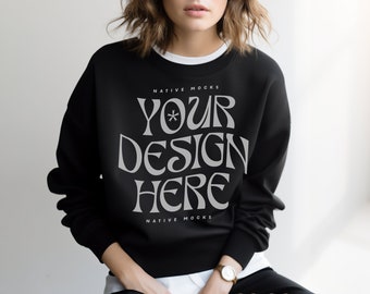 May include: Black sweatshirt with the text "YOUR DESIGN HERE" in a stylized font. The text is in gray and is centered on the front of the sweatshirt. The sweatshirt has a crew neck and long sleeves.