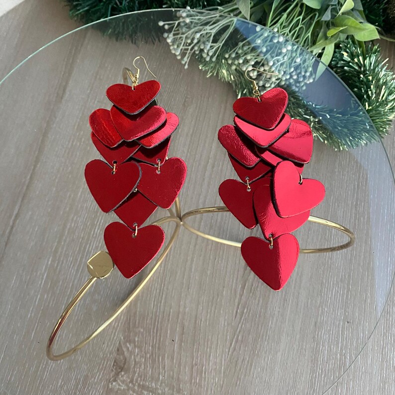 Red Christmas heart earrings made from layered leather, a festive handmade jewelry piece.