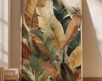 May include: A framed botanical print featuring large, stylized leaves in shades of green, gold, and brown. The artwork is set against a neutral background and framed in a light wood. The print leans against a wall, with books and a plant visible.