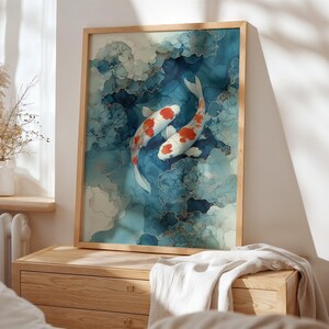 Puede incluir: Impresi&oacute;n art&iacute;stica enmarcada que presenta dos carpas koi con marcas rojas y blancas nadando en un fondo abstracto azul y blanco. La obra de arte tiene detalles dorados y se exhibe en una c&oacute;moda de madera.