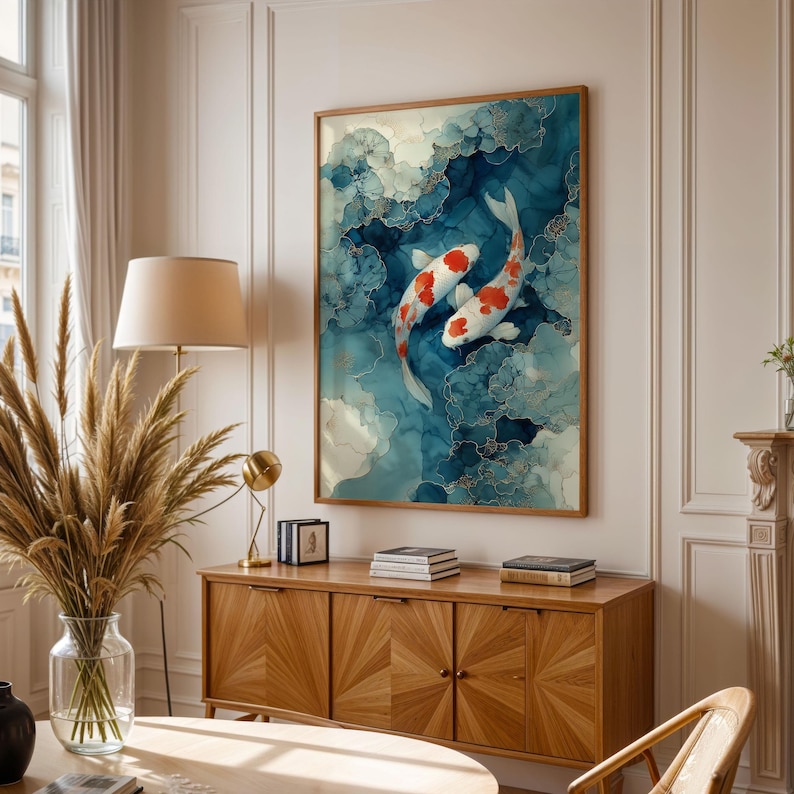 Puede incluir: Una obra de arte enmarcada con dos peces koi nadando en un fondo abstracto azul y blanco. Los peces son blancos con marcas rojas. La obra est&aacute; en un marco de madera y cuelga de una pared blanca.