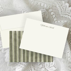May include: Ivory stationery set with an envelope, a card, and a patterned card. The patterned card has vertical stripes in shades of green and white. The card is printed with the name "Katherine Smith" in elegant script.