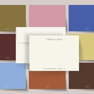 May include: A stationery set featuring a cream-colored card and envelope, with the name "Katherine Smith" and address printed in black. Surrounding the set are various colored cards in shades of olive, pink, blue, burgundy, yellow, light blue, rust, and brown.