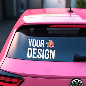 May include: Pink car with a rear window decal that reads "YOUR DESIGN" in white block letters, accompanied by a small flower graphic. The car has a red brake light and a black antenna.