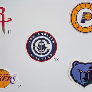 May include: Five different NBA team logos on a white background. The logos are for the Houston Rockets, Indiana Pacers, Los Angeles Clippers, Los Angeles Lakers, and Memphis Grizzlies.