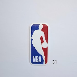 May include: A white silhouette of a basketball player dribbling a ball against a blue and red background. The logo says "NBA" in white letters. The number "31" is printed below the logo.