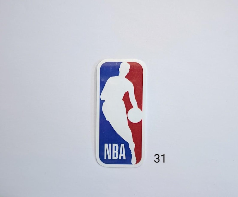 May include: A white silhouette of a basketball player dribbling a ball against a blue and red background. The logo says "NBA" in white letters. The number "31" is printed below the logo.