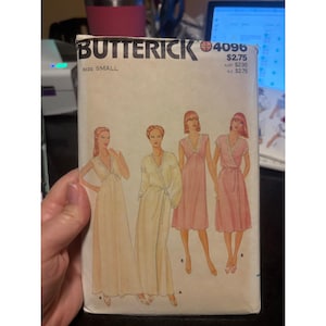 Peut inclure: Une enveloppe de patron de couture Butterick vintage avec des illustrations de quatre modèles de robes différents. L'enveloppe est de couleur crème avec le logo Butterick et le numéro 4096. Taille petite.