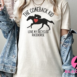 May include: A white t-shirt with the text "The Comeback Kid" and a silhouette of a jockey riding a horse with a red heart. The text "Love my recycled racehorse" is below the image.