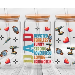 May include: Three glass tumblers with bamboo lids and straws. The tumblers are decorated with images of tools, hearts, watches, and stars. The word "DAD" is displayed vertically, with words like "Devoted" and "Fearless" below.