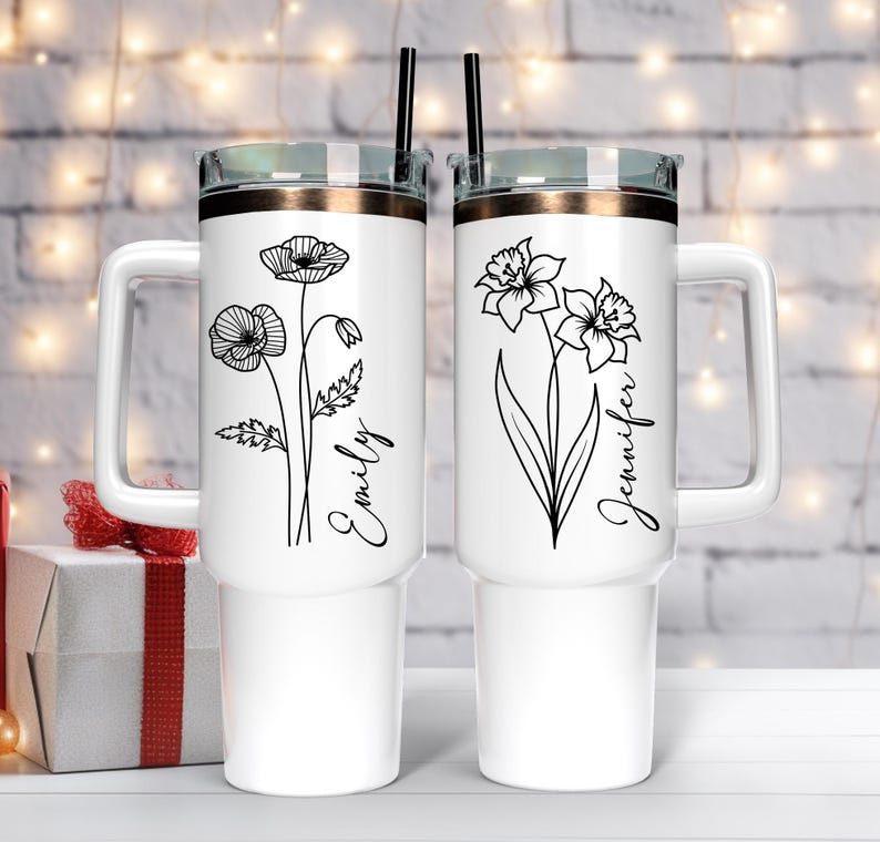 Pu&ograve; includere: Due tazze da viaggio in acciaio inox bianco con disegni floreali neri e nomi personalizzati. La tazza a sinistra ha un disegno di papavero e il nome "Emily". La tazza a destra ha un disegno di narciso e il nome "Jennifer".