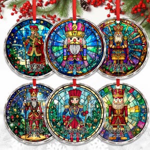 May include: Six round ceramic ornaments featuring colorful stained glass style illustrations of nutcracker figures. Each ornament displays a unique character, a personalized name, and the year 2026 in black script text against a vibrant background.