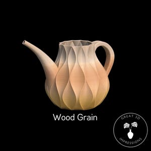 Puede incluir: Una tetera de cerámica con un acabado de grano de madera. La tetera tiene un cuerpo redondeado con una superficie texturizada y un pico en el lateral. La tetera es de color marrón claro con un degradado de color de claro a oscuro. La tetera está sobre un fondo negro.