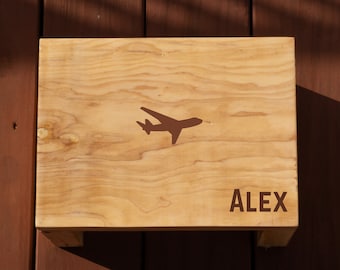 May include: A wooden step stool with a brown airplane silhouette and the name "ALEX" painted on the top.