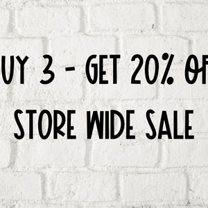 May include: White brick wall with black text that reads "BUY 3 - GET 20% OFF STORE WIDE SALE".