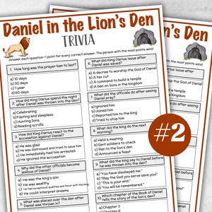 May include: Two printed trivia game sheets titled "Daniel in the Lion's Den Trivia." The sheets have questions and answers about the biblical story. A brown circle with the number "#2" is in the foreground.