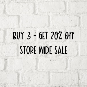 Pu&ograve; includere: Muro di mattoni bianchi con testo nero che dice "BUY 3 - GET 20% OFF STORE WIDE SALE"
