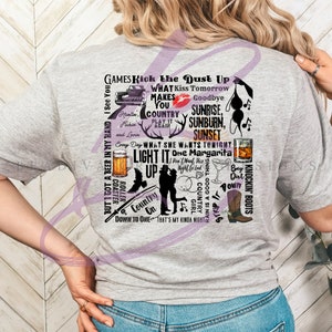 May include: A gray t-shirt with a design featuring a variety of country music and lifestyle related phrases and images. The text includes "Kick the Dust Up", "What She Wants Tonight", "One Margarita", "Country Girl", "Down to One", "Light It Up", "Sunrise", "Sunburn", "Sunset", and "Knockin' Boots".