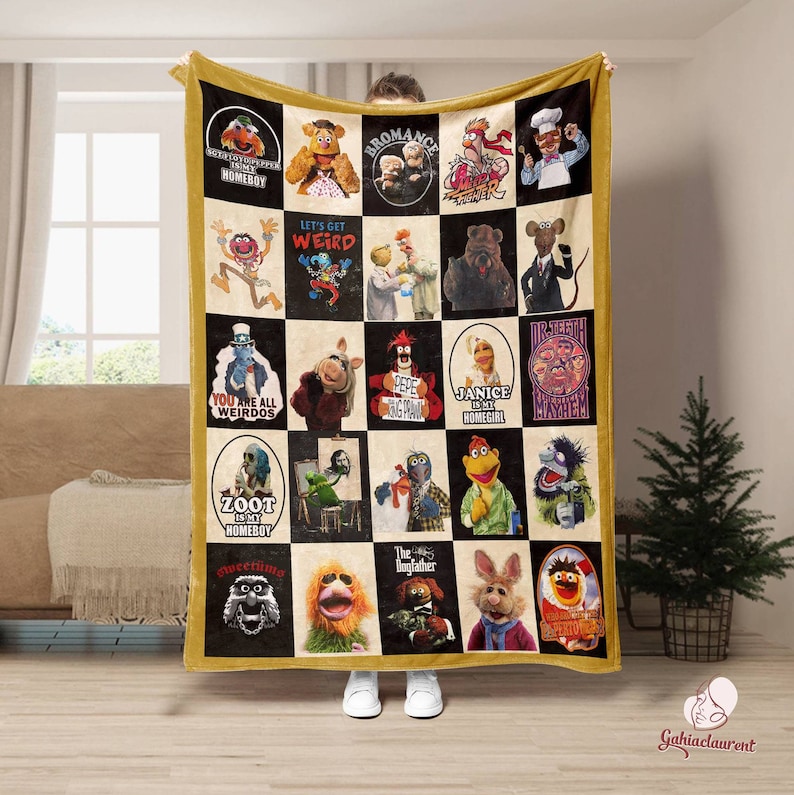 Puede incluir: Una manta de franela a cuadros amarillos y negros con un collage de im&aacute;genes de personajes del programa de televisi&oacute;n de los Muppets. La manta presenta im&aacute;genes de personajes como Miss Piggy, Kermit la rana, Fozzie Bear y Animal. La manta tambi&eacute;n incluye texto como "Let's Get Weird", "You Are All Weirdos" y "Zoot is My Homeboy".