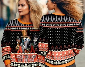 May include: Black Christmas sweater with an orange collar and cuffs. The sweater features a design with Muppet characters, snowflakes, and the text "LIGHT THE LAMP NOT THE RAT". The back of the sweater has a similar pattern.