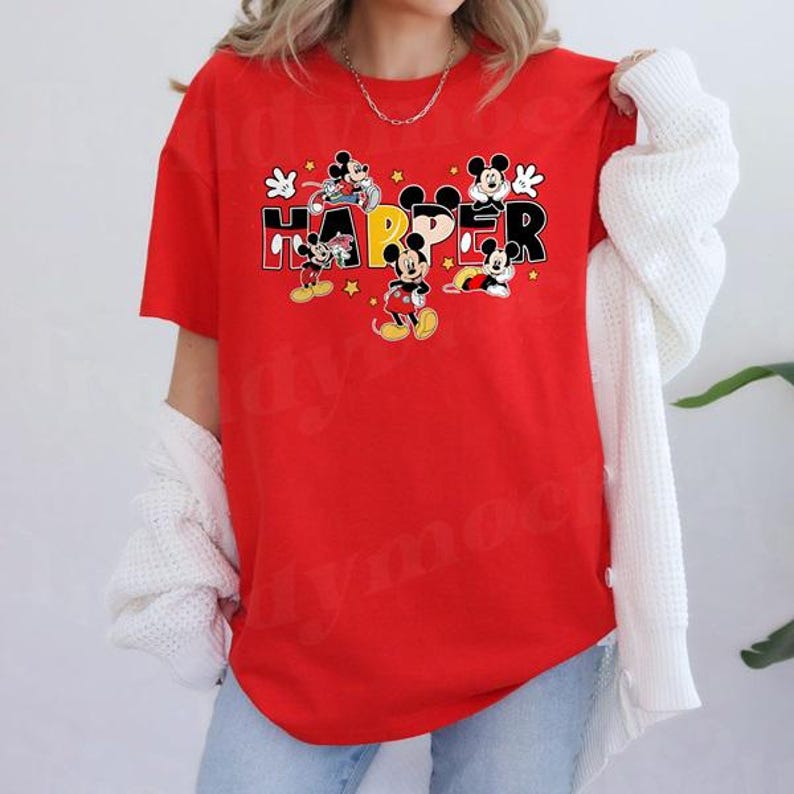 A person wearing a red t-shirt with the word "HAPPY" printed on it, along with various Disney characters.