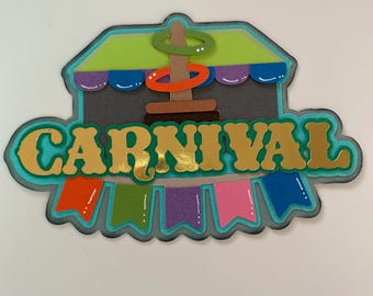 May include: A teal blue and green carnival sign with the word "CARNIVAL" in gold letters. The sign features a ring toss game with colorful rings and a brown stand.
