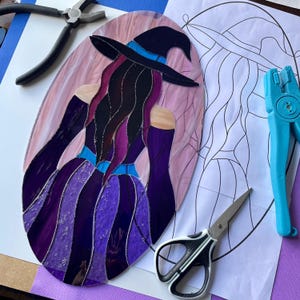 Könnte beinhalten: Drei cremefarbene Keramikbecher mit gesprenkelter Glasur. Jeder Becher zeigt ein handgemaltes Blumenmuster in Blau-, Grün- und Gelbtönen. Die Becher haben eine einfache, abgerundete Form und einen bequemen Griff.