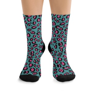 May include: A pair of teal blue socks with a pink leopard print pattern.