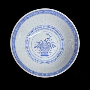 May include: A white ceramic bowl with a blue and white floral design. The bowl has a scalloped edge and a blue and white border.