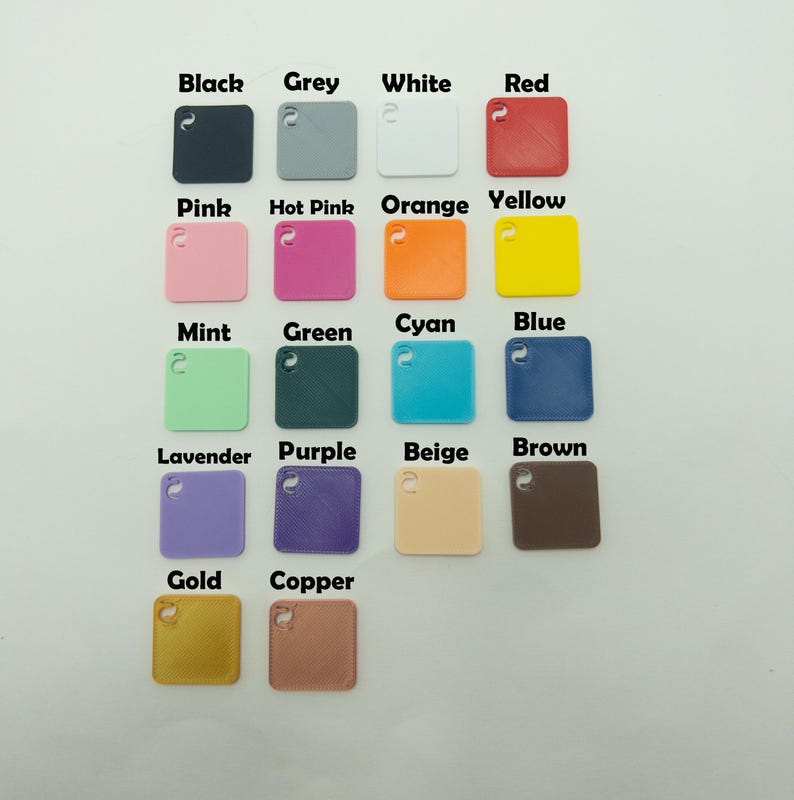 May include: A selection of small, square colour swatches in various shades, including black, grey, white, red, pink, hot pink, orange, yellow, mint, green, cyan, blue, lavender, purple, beige, brown, gold, and copper. Each swatch has a small hole.