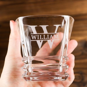 Puede incluir: Un vaso de rocas de vidrio transparente con base cuadrada y dise&ntilde;o personalizado. El vaso tiene la letra "W" grabada en la parte delantera con el nombre "William" debajo.