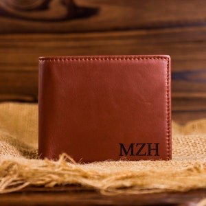May include: A brown leather wallet with the initials "MZH" embossed on the front.