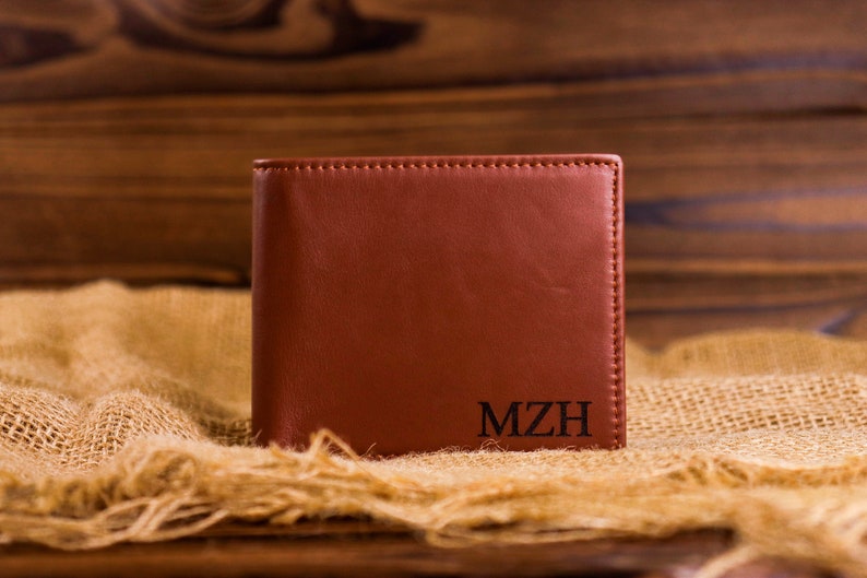 May include: A brown leather wallet with the initials "MZH" embossed on the front.