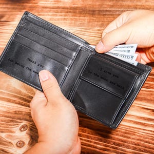 May include: A black leather wallet with a personalized message inside. The message reads "Thank you for being the best" on one side and "I love you to the moon and back" on the other side.