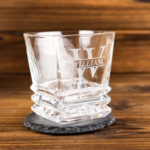 Puede incluir: Un vaso de vidrio transparente con forma cuadrada y base texturizada. El vaso tiene una gran inicial "W" grabada en la parte delantera con el nombre "William" debajo.