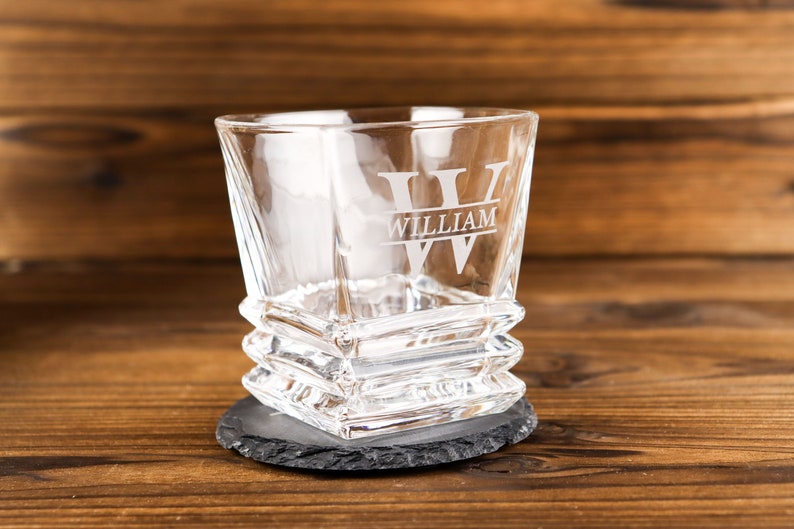 Puede incluir: Un vaso de vidrio transparente con forma cuadrada y base texturizada. El vaso tiene una gran inicial "W" grabada en la parte delantera con el nombre "William" debajo.