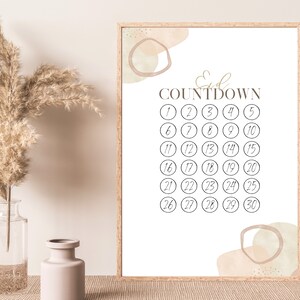 Può includere: Un calendario di conto alla rovescia stampabile con il testo "Eid Countdown" e i numeri da 1 a 30 in cerchi. Lo sfondo è un rettangolo bianco con forme astratte in beige e verde chiaro.