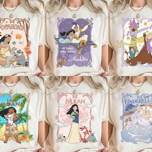 K&ouml;nnte beinhalten: Sechs cremefarbene T-Shirts, jedes mit einem Disney-Prinzessinnen-Design. Die Designs zeigen Pocahontas, Aladdin, Rapunzel, Moana, Mulan und Cinderella mit farbenfrohen Illustrationen und Text.
