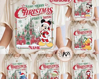 May include: A cream-colored t-shirt featuring a festive graphic with a red and green castle, snowflakes, and a cartoon character in a Santa suit. The text reads Very Merry Christmas Party 2026 and Name. The design is framed by a thin red border.