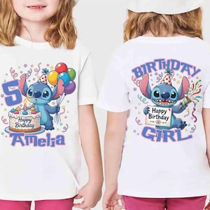 May include: White t-shirt featuring a cartoon character holding balloons and a birthday cake. The front of the shirt has the number 5 and the name "Amelia". The back of the shirt says "Birthday Girl".