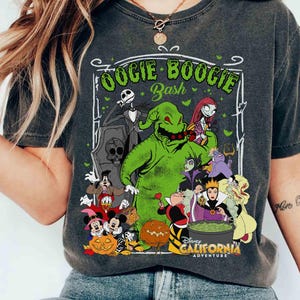May include: Dark gray t-shirt featuring a graphic of Disney characters, including Oogie Boogie, Jack Skellington, and Mickey Mouse. The text "Oogie Boogie Bash" and "Disney California Adventure" are also visible. The shirt has a vintage, worn look.