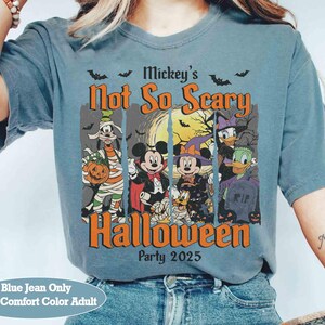 May include: Blue jean-colored t-shirt featuring a Halloween design with Mickey Mouse and friends. The graphic includes the text "Mickey's Not So Scary Halloween Party 2025". The shirt is a comfort color adult size.